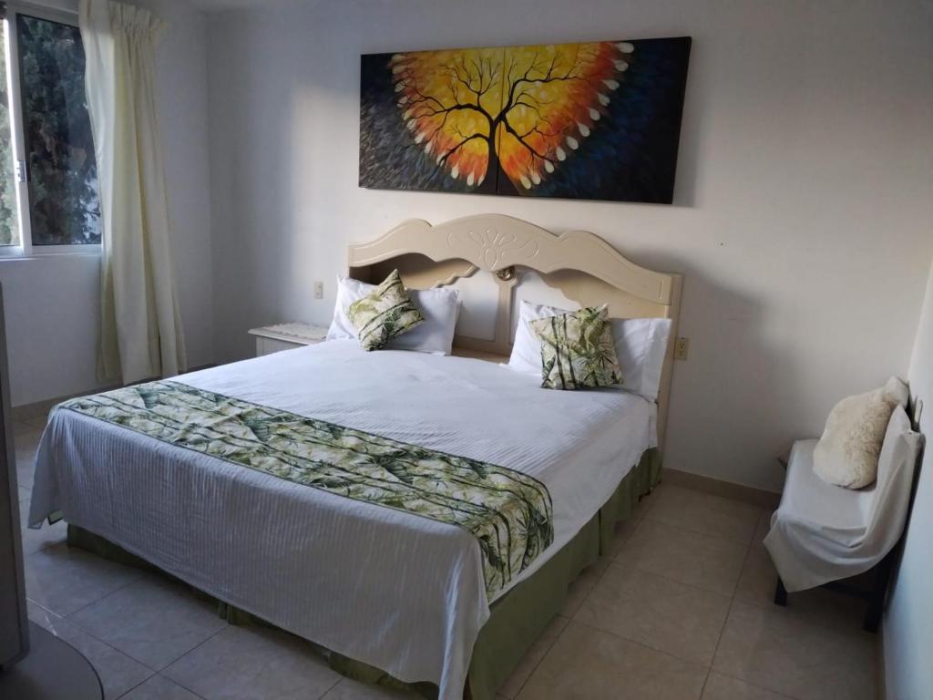 1 dormitorio con 1 cama y una pintura en la pared en Hospedaje Familiar en Oaxaca de Juárez