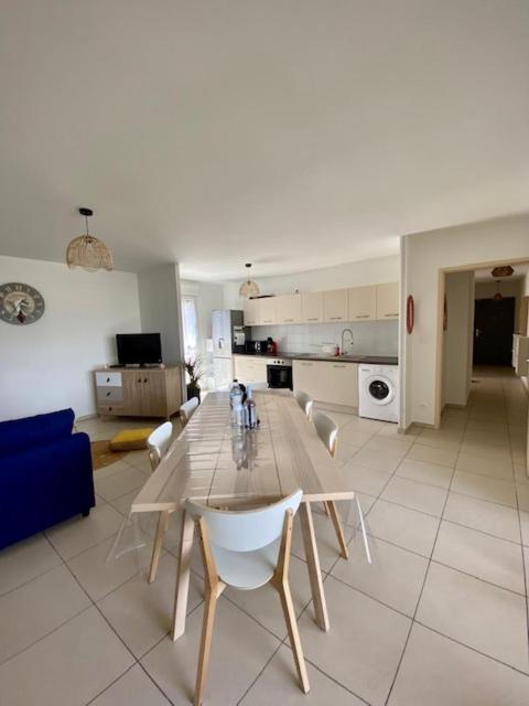 a dining room and kitchen with a table and chairs at Bel appartement entre terre et mer in Sarrola-Carcopino