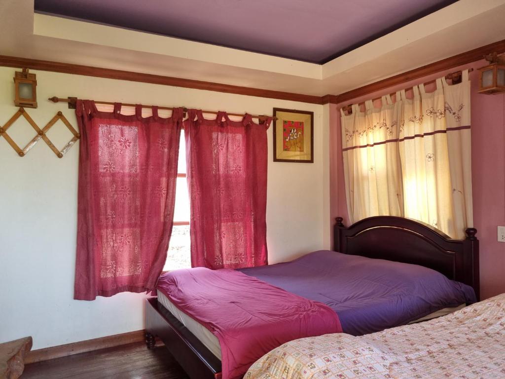 - une chambre avec un lit et une fenêtre avec des rideaux rouges dans l'établissement Hello Sichang Bungalow, à Ko Sichang