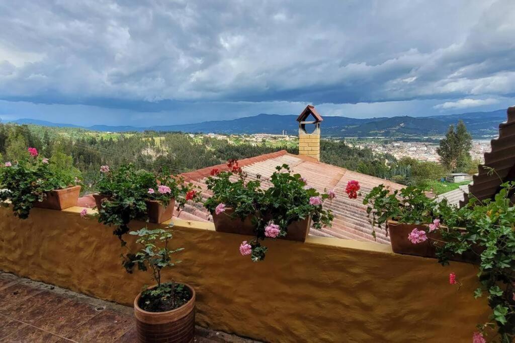 a balcony with potted plants on top of a house at La Rosaleda 1 - Hermosa finca en Paipa in Paipa