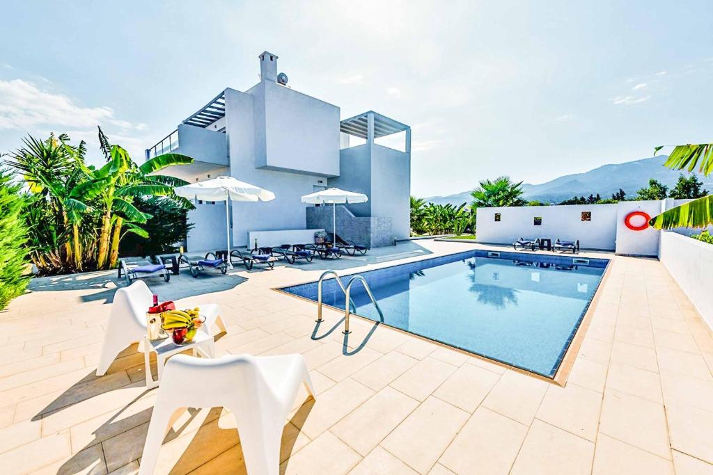 a villa with a swimming pool and a resort at Villa Xenos Tria in Tigaki
