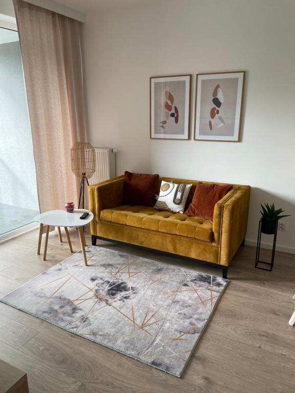 sala de estar con sofá amarillo y mesa en Modern Tower Apartament Gdynia en Gdynia