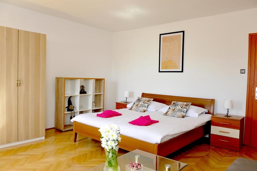 ein Schlafzimmer mit einem Bett mit rosa Kissen darauf in der Unterkunft Spalato in Split