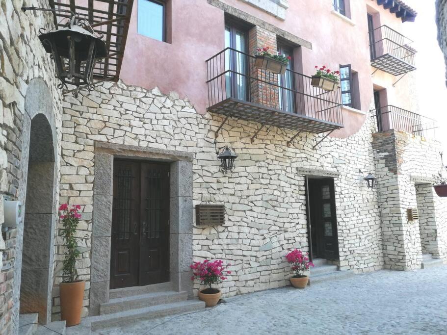 a stone building with potted plants and a balcony at Hermoso Loft en Valquirico, Lofts Frontana. in Tlaxcala de Xicohténcatl