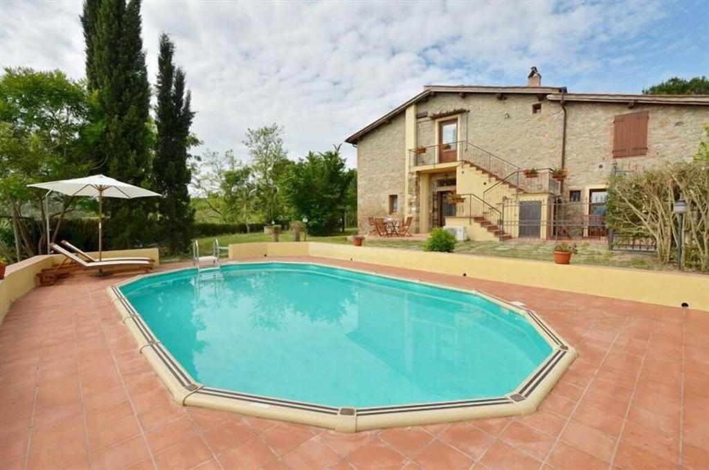 un'immagine di una piscina di fronte a una casa di Podere Vigna del Sole a San Gimignano