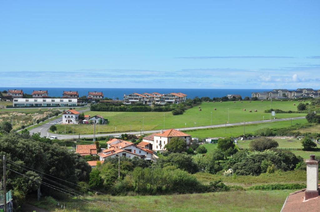 Une ville avec des maisons et l'océan en arrière-plan dans l'établissement Sopelana,Uribe Kosta. Naturaleza, armonía, deporte, à Sopelana