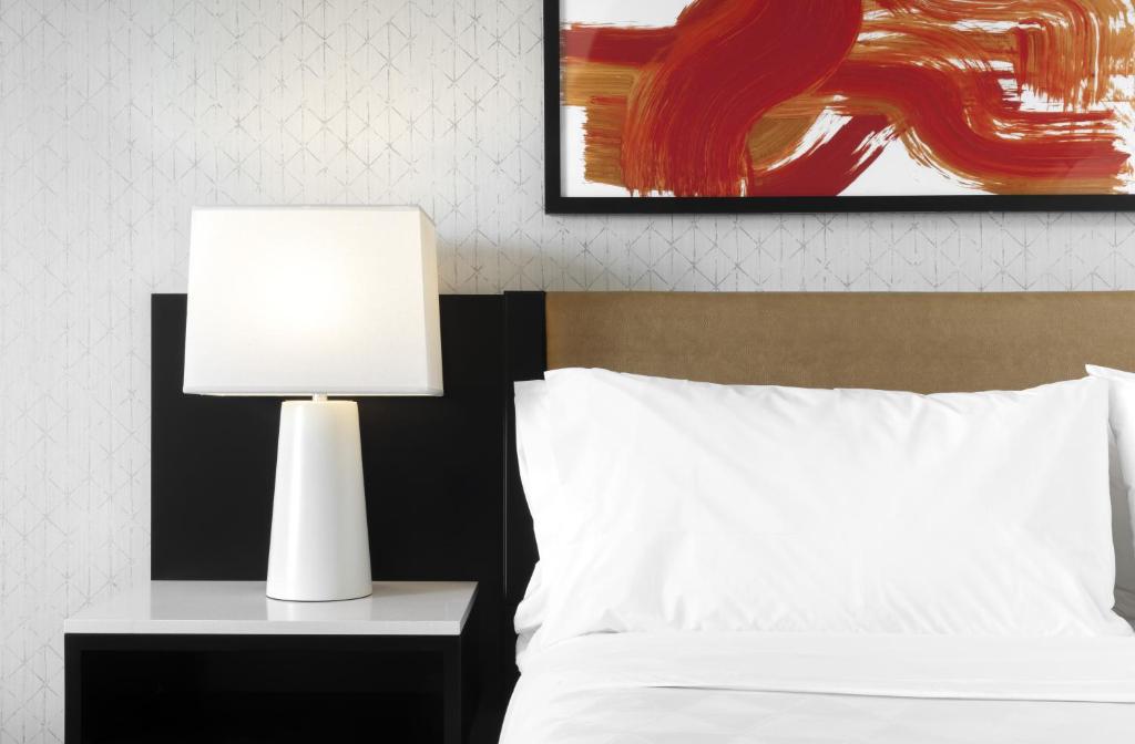 a white lamp on a night stand next to a bed at Holiday Inn - Chicago Dwtn - Wolf Point, an IHG Hotel in Chicago