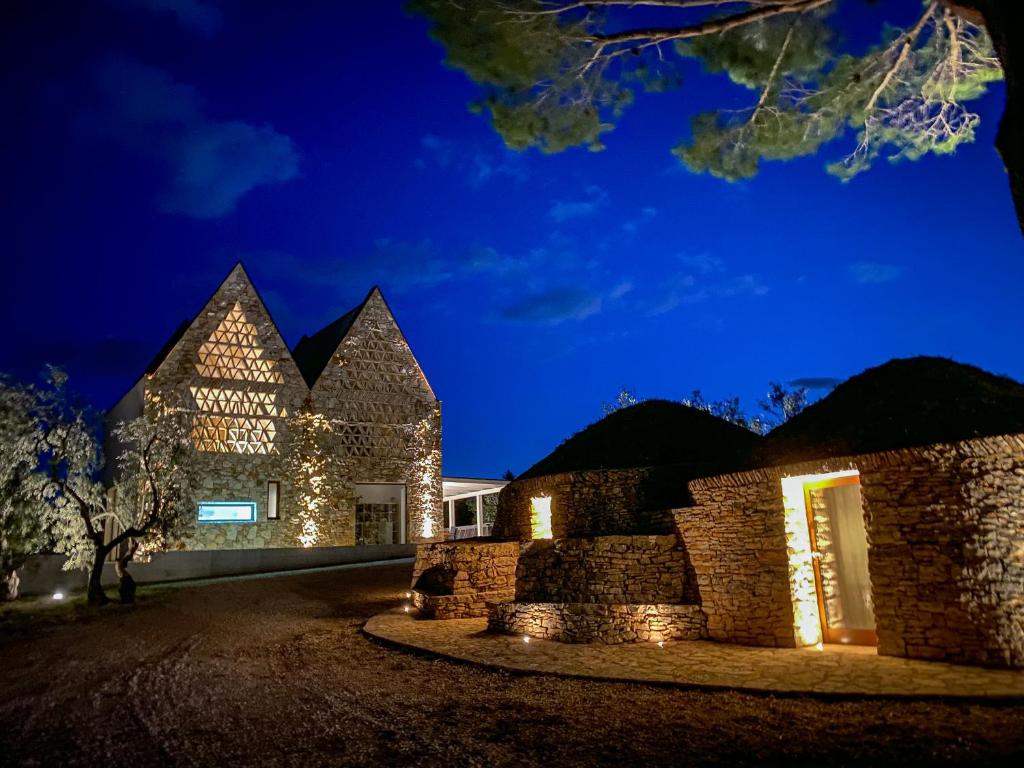 um edifício de pedra com luzes acesas à noite em Casale Amendolagine em Terlizzi