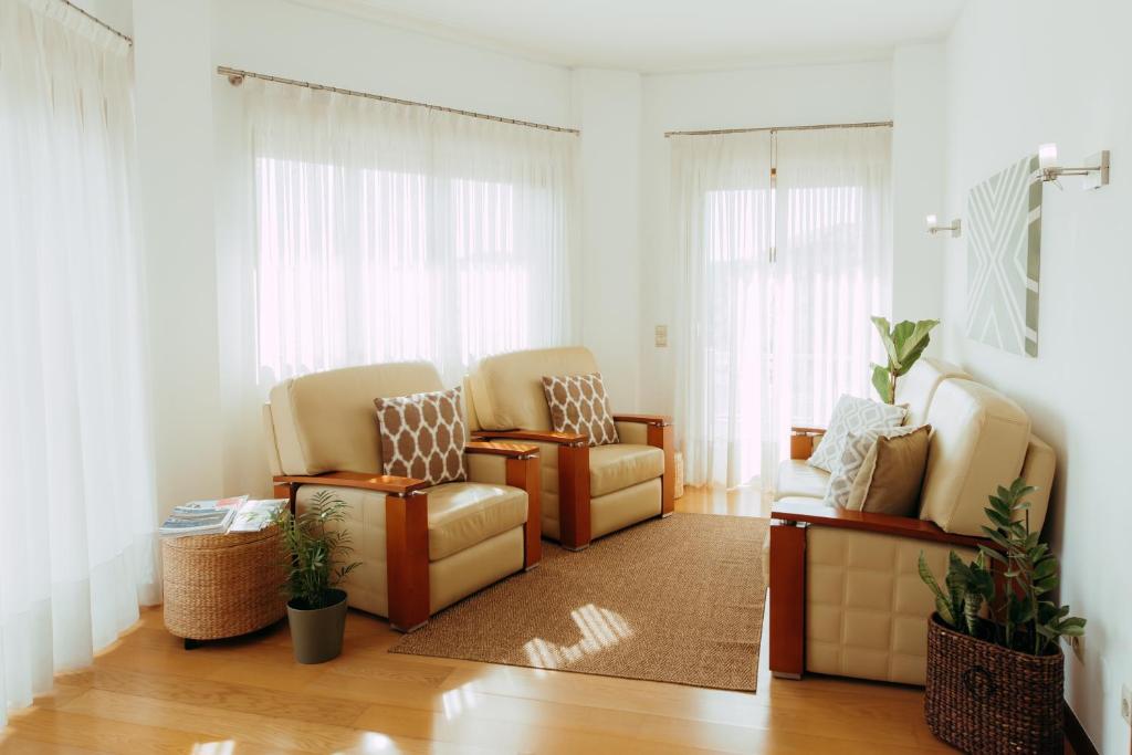 sala de estar con 2 sillas y alfombra en RACIA Lodges - Apartment en Viana do Castelo