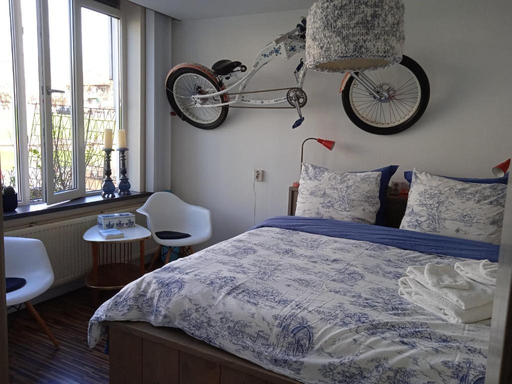 a bedroom with a bed and a bike hanging on the wall at Bed and Breakfast Amsterdam West in Amsterdam