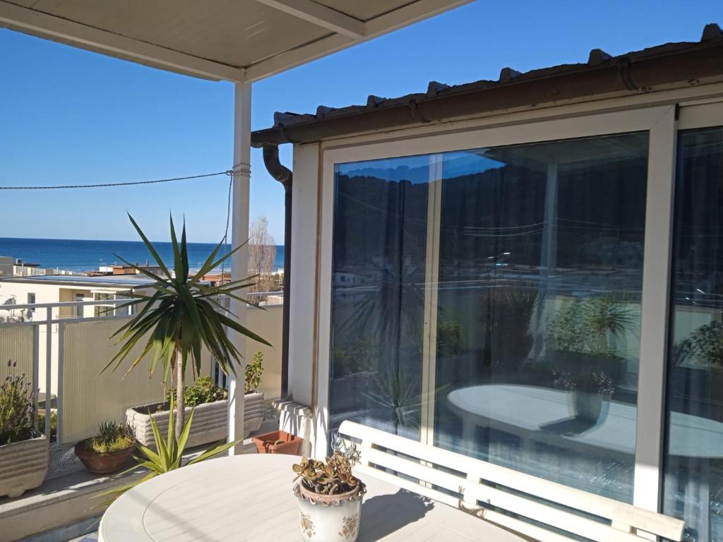 balcón con mesa y vistas al océano en Terrazza su Serapo, en Gaeta