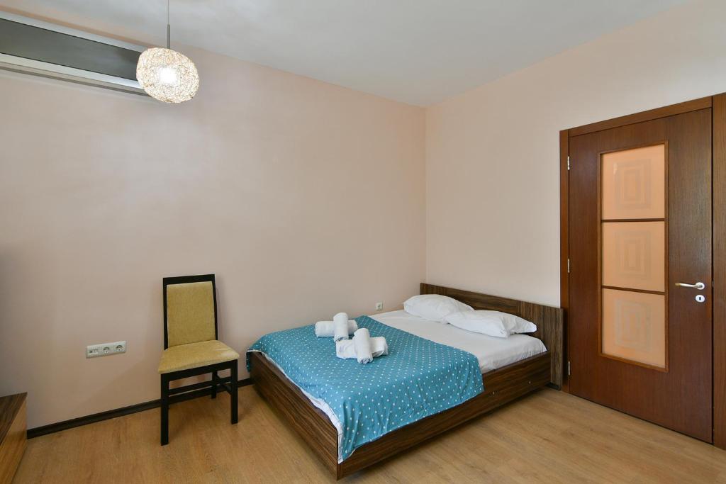 ein Schlafzimmer mit einem Bett mit einem Stuhl und Kerzen darauf in der Unterkunft Budget central next to sea garden and beach in Warna