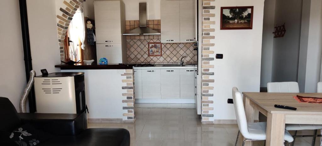 a kitchen with white cabinets and a wooden table at 3M - seahouse in Porto Cesareo