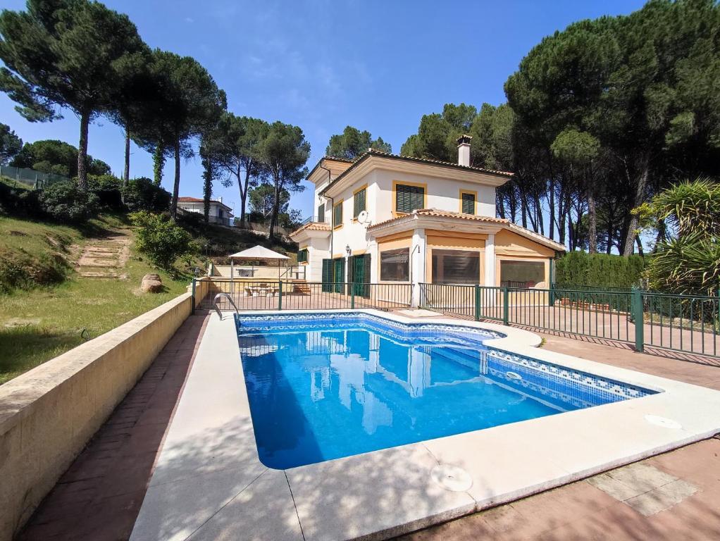 a villa with a swimming pool in front of a house at La casa de Mati in Córdoba