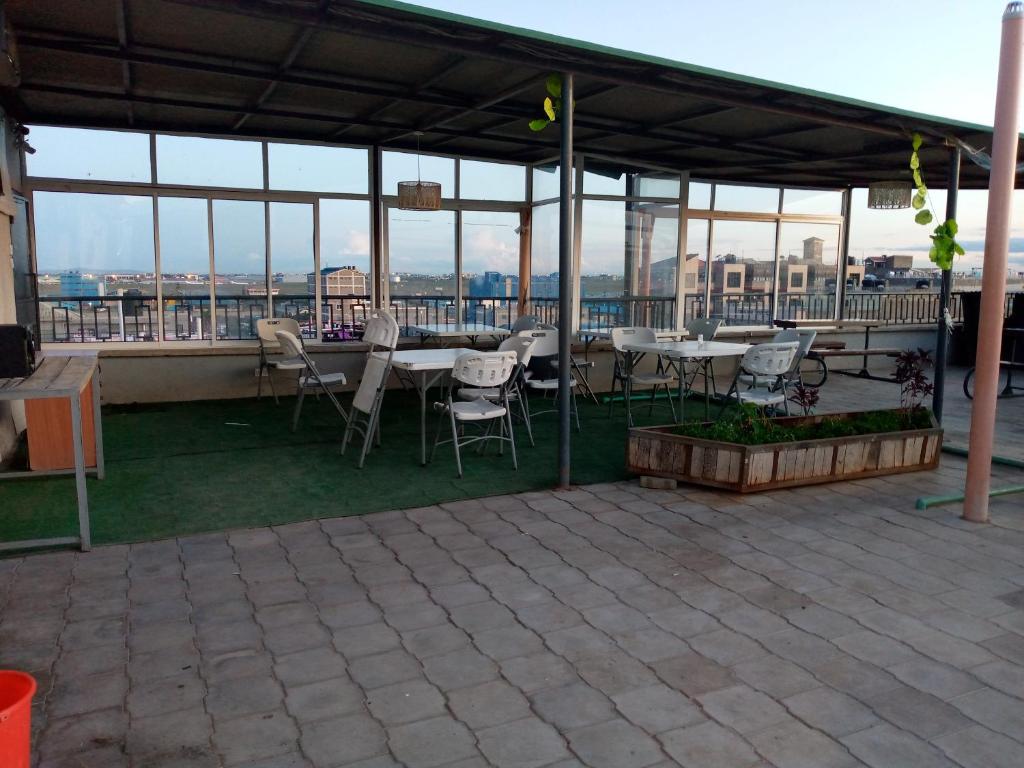 een patio met tafels en stoelen op een dak bij Rew Apartment in Nairobi