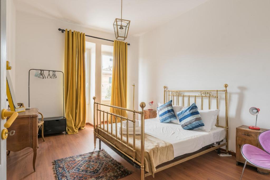 a bedroom with a bed with blue and white pillows at Stylish Pigneto Apartment in Rome