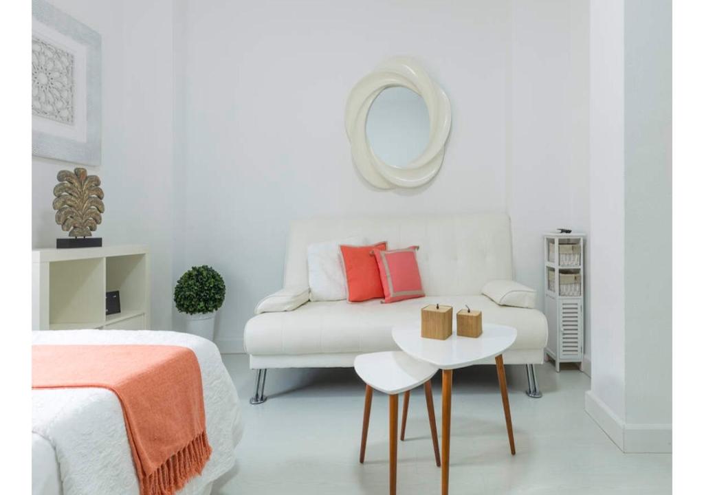 a bedroom with a bed and a table and a mirror at Lovely studio at the city heart! in Málaga