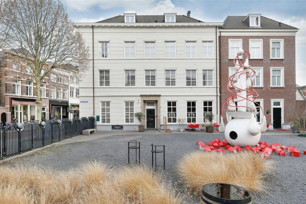 a large white building with a statue in front of it at Boutique Hotel Jeroen in Den Bosch