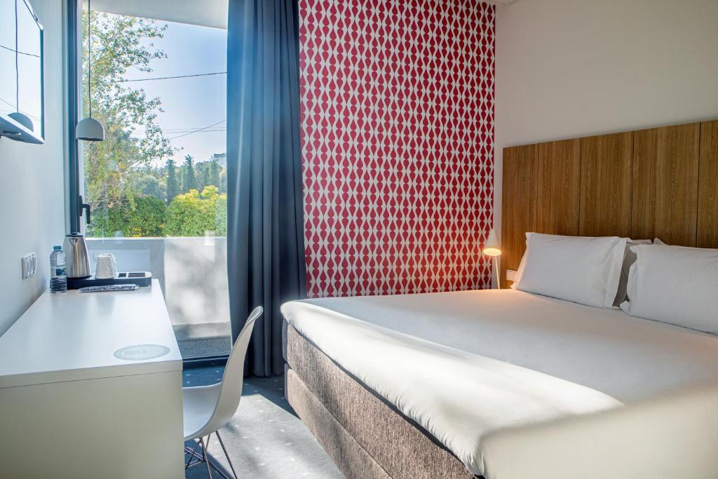 a room with a bed and a desk and a window at Stay Hotel Lisboa Aeroporto in Lisbon