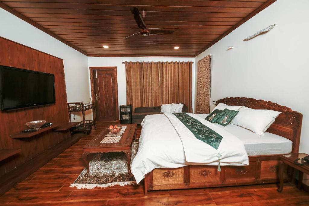 - une chambre avec un lit et une télévision à écran plat dans l'établissement The Gardenia7, à Srinagar