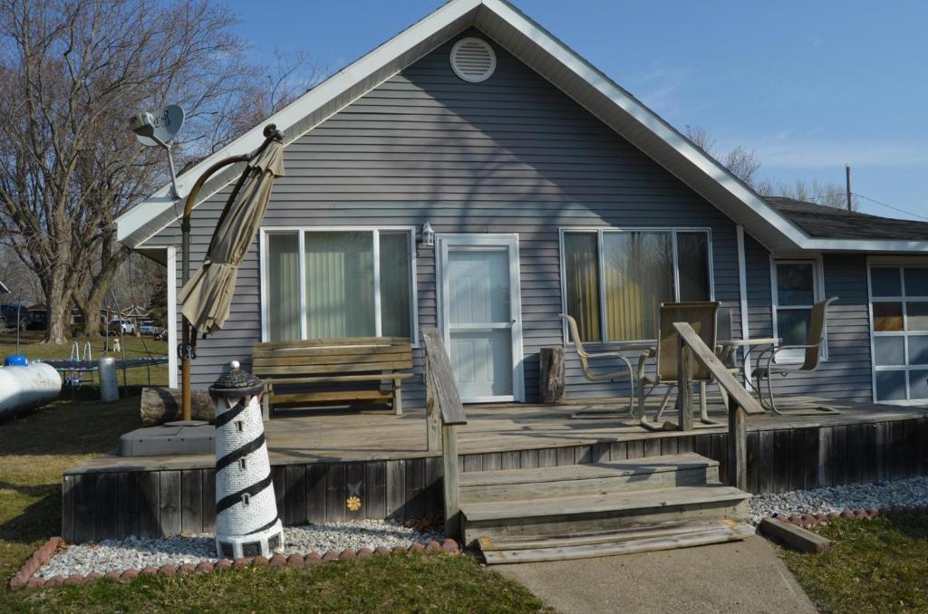 ein Haus mit einer hölzernen Veranda mit einer Flagge in der Unterkunft 25710 Walleye Dr in Spirit Lake