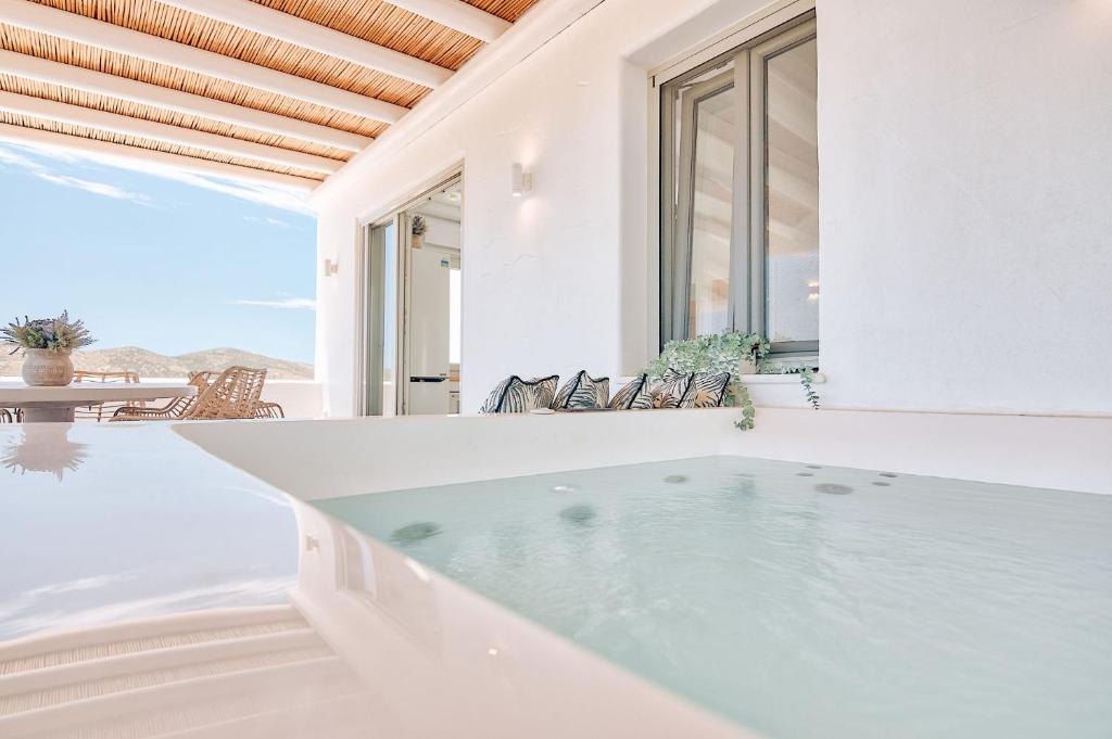 una vasca da bagno in una camera bianca con vista sull'oceano di Antiparos Thea a Andiparos