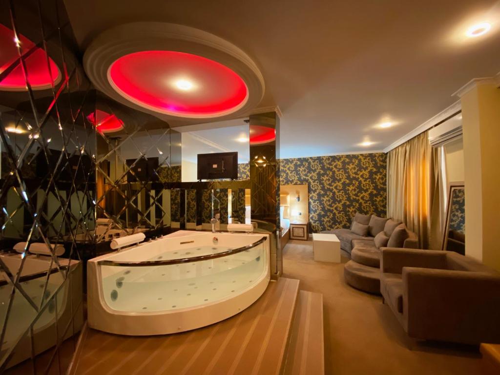 a large living room with a tub in the middle at Hotel Deluxe in Tirana