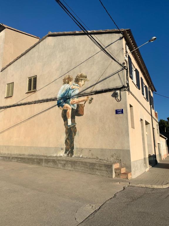 un mural de dos personas al lado de un edificio en Cal Franciscu, Casa a Casserres en Caserras