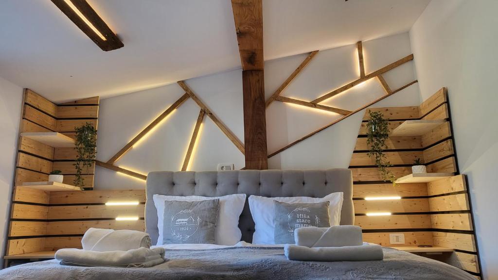 1 dormitorio con 1 cama grande con almohadas blancas en Hiša stare mame en Kamnik