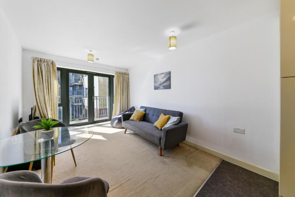 a living room with a couch and a glass table at Luxe 1 bed flat 5 mins to Stratford - Free Parking in London