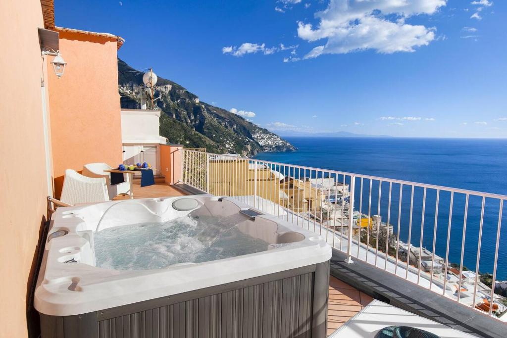 una vasca idromassaggio su un balcone con vista sull'oceano di BlueVista Dreamscape Home -Terrace Jacuzzi/Hot Tub a Positano
