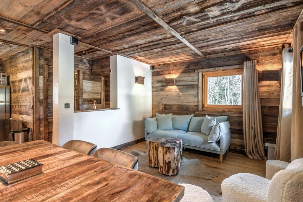 a living room with a table and a couch at Exceptional flat in a chalet - Megève - Welkeys in Megève