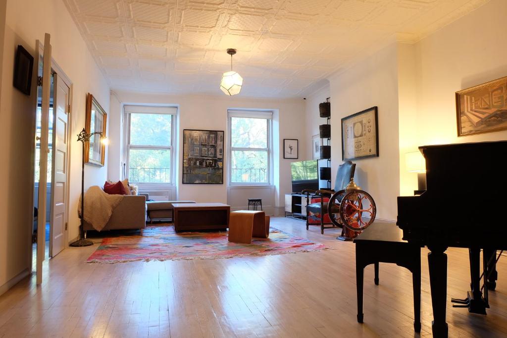 a living room with a piano and a couch at 1830’s Historic Merchant House on the park LES in New York