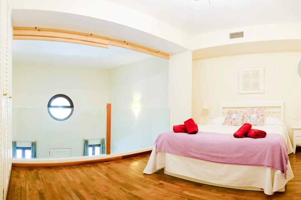 a bedroom with a bed with red pillows on it at Duplex near MEZQUITA of Córdoba & Free Private Parking in Córdoba