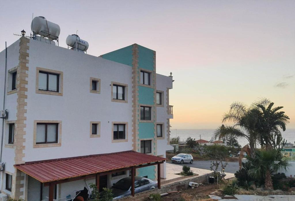 a large white building with satellites on top of it at JOANNA SUNSET APTS Pomos in Pomos