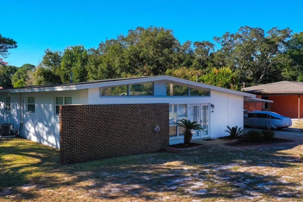a house with a brick fence in a yard at Cathy and Jim's Florida Beach House in Fort Walton Beach