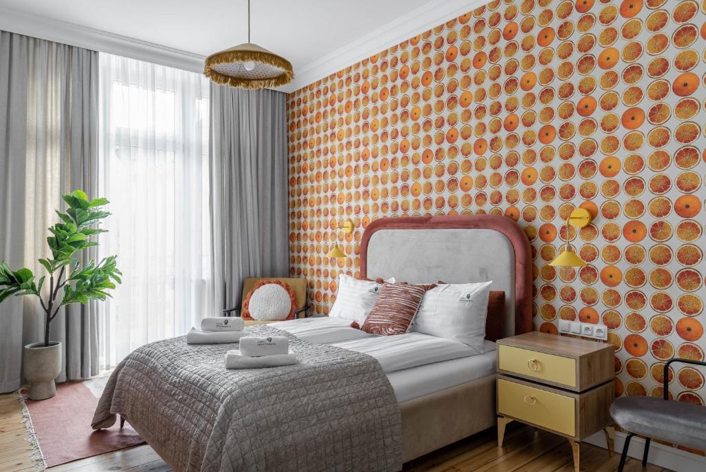 a bedroom with a bed with an orange wall at Lion Apartments -Juicy Sopot Premium Familly Stay 200 m from the sea in Sopot