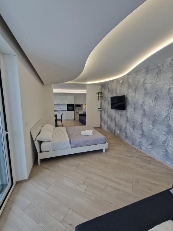 een slaapkamer met een bed en een tv aan de muur bij B&B Dama3 in Barletta