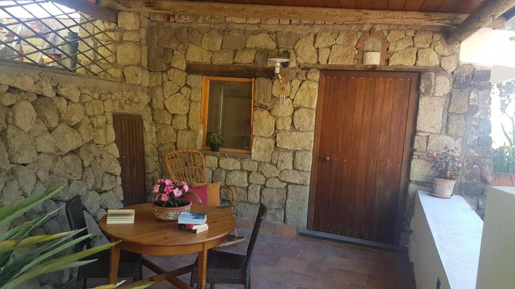 um quarto com uma mesa de madeira e uma parede de pedra em mini appartamenti baciati dal sole em Ischia