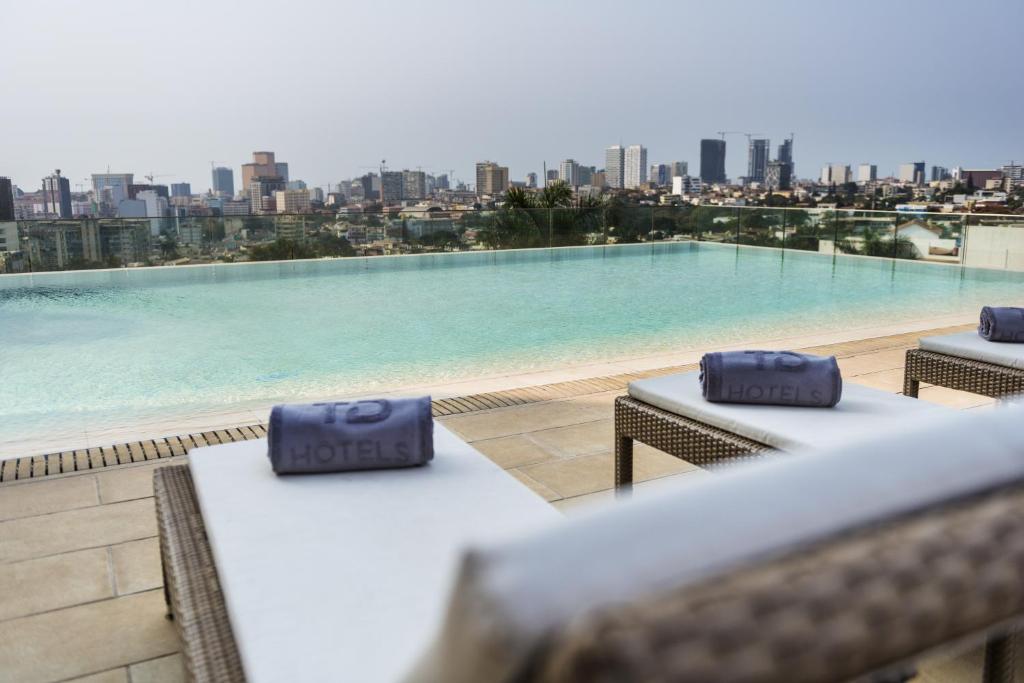 Blick auf den Pool vom Dach eines Gebäudes in der Unterkunft Hotel Alvalade in Luanda