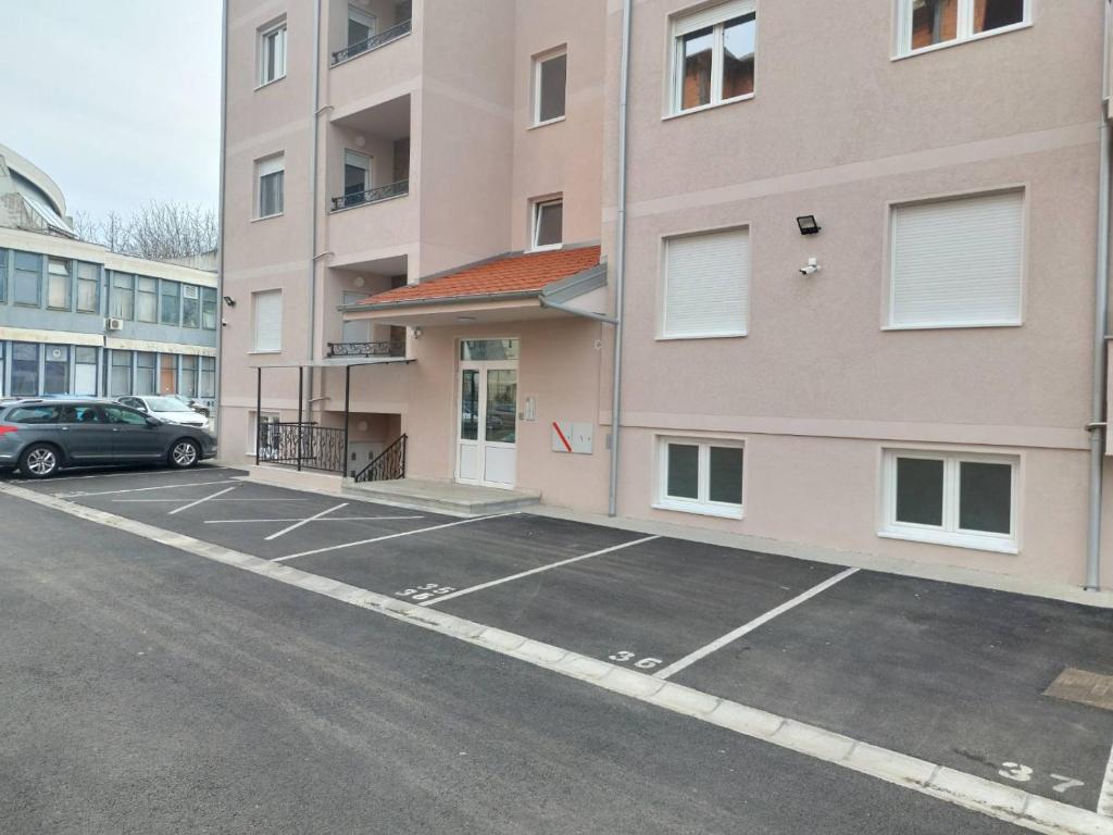 un aparcamiento vacío frente a un edificio en Happy Day en Obrenovac