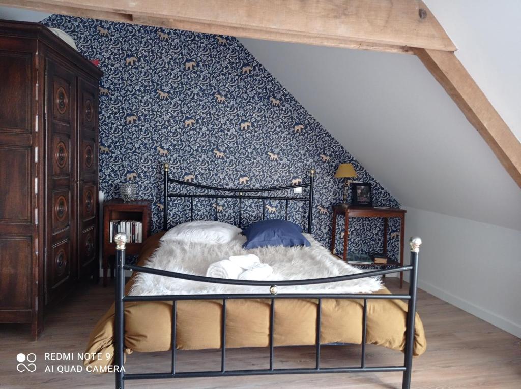 1 dormitorio con 1 cama con pared azul en Chez Catherine, en Rochefort-en-Terre