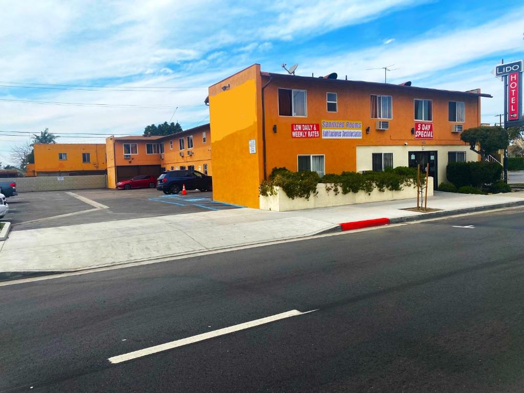 un edificio arancione sul lato di una strada di Lido Hotel a Huntington Park