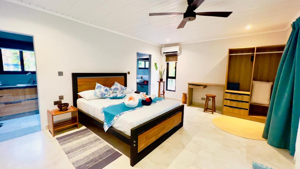 Schlafzimmer mit einem Bett und einem Deckenventilator in der Unterkunft Le Port Guest House in Baie Sainte Anne