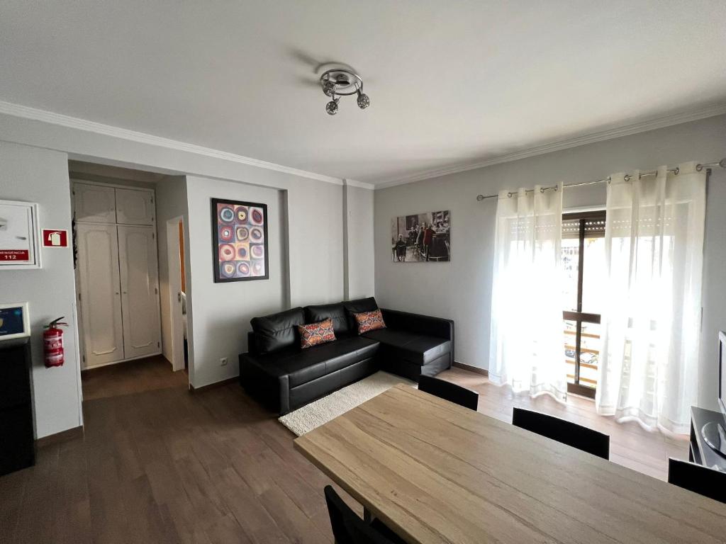 a living room with a black couch and a table at Apartamento Barão in Amora