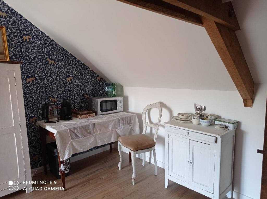 a small kitchen with a table and a microwave at Chez Catherine in Rochefort-en-Terre