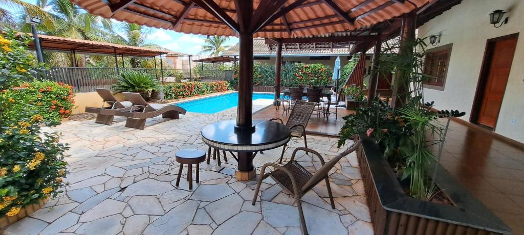 um pátio com uma mesa e cadeiras e uma piscina em Pousada Villa D' Garden em Ribeirão Preto