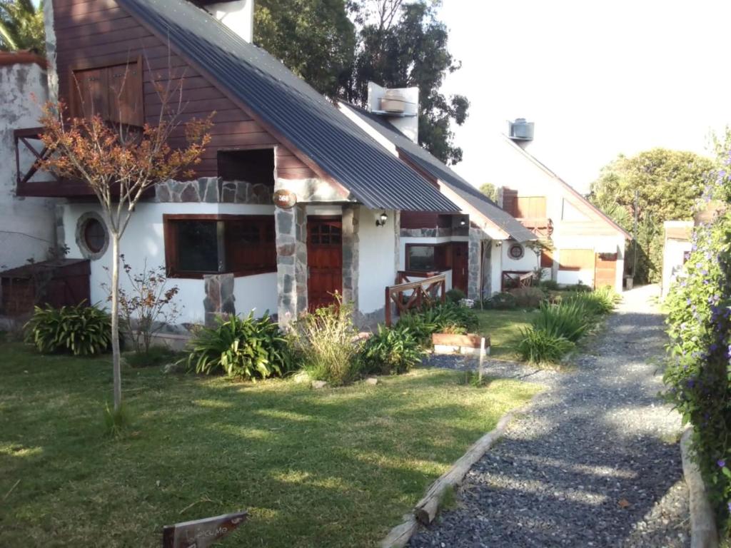 uma casa com um caminho que leva ao jardim da frente em Complejo de Cabañas lo de Otto , Los Acantilados , Mar del plata em Mar del Plata