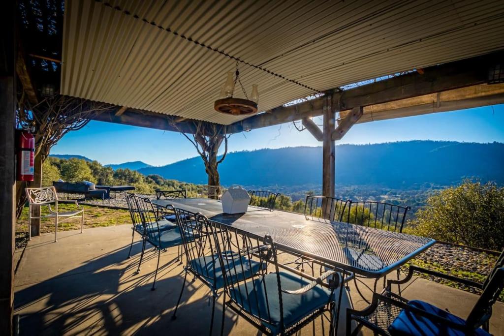 a table and chairs on a patio with a view at Fairy Tale 13-acre Sunset Villa at Windy Gap Valley near Yosemite in Ahwahnee