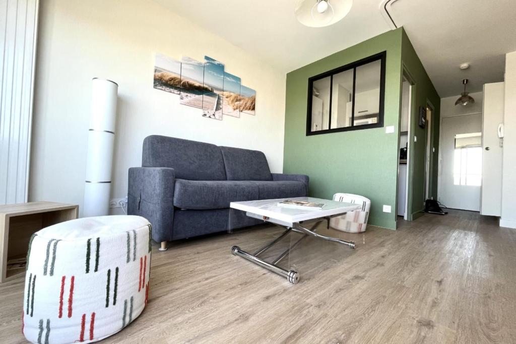 ein Wohnzimmer mit einem Sofa und einem Tisch in der Unterkunft Pretty and bright studio with view on the harbor in Les Sables-dʼOlonne